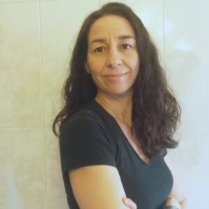 María Ángeles Abadía tiene pelo largo ondulado y castaño, ojos castaños y camiseta negra con cuello de pico